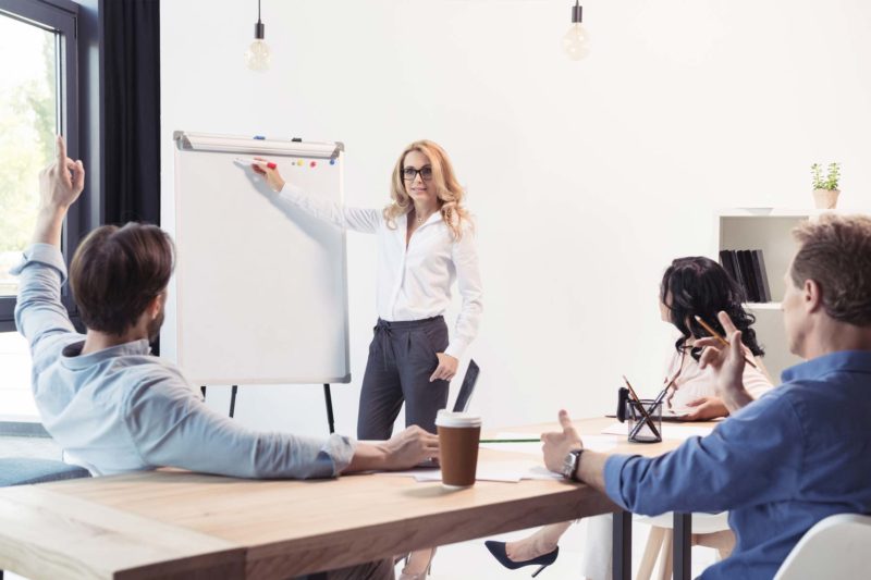 Woman Writing On WhiteBoard In Conference Room