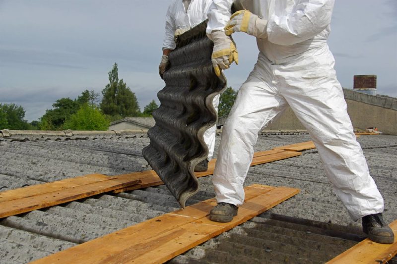 Roofers Moving Tile On Top Of Building
