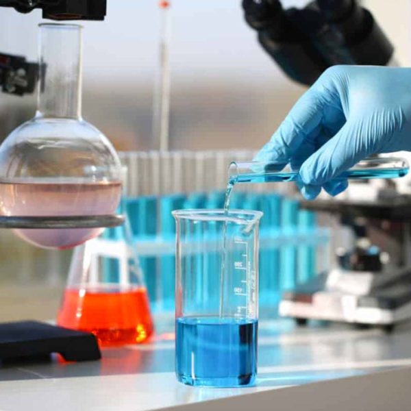 Technician Pouring Chemicals In To A Beaker