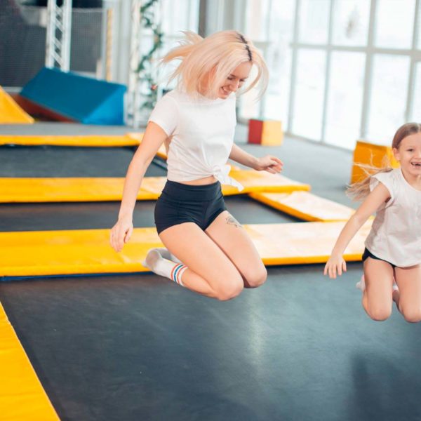 Mom And Daughter Bouncing On Trampoline
