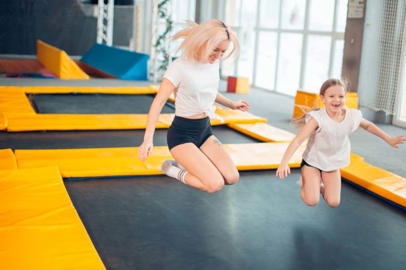 Mom And Daughter Bouncing On Trampoline