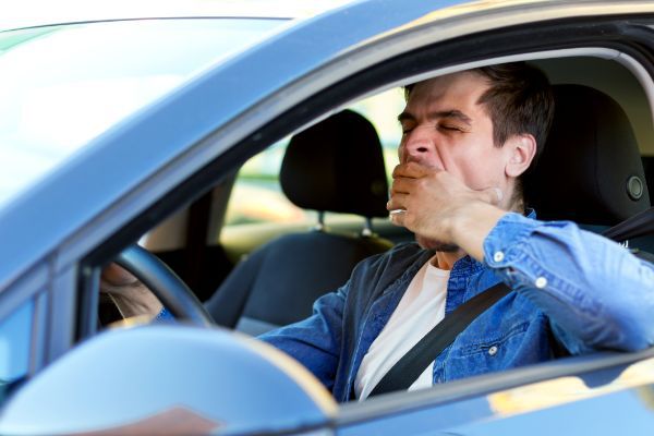 Drowsy Man Driving A Car While Yawning