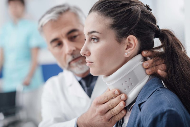 Doctor Placing Neck Brace On Patient